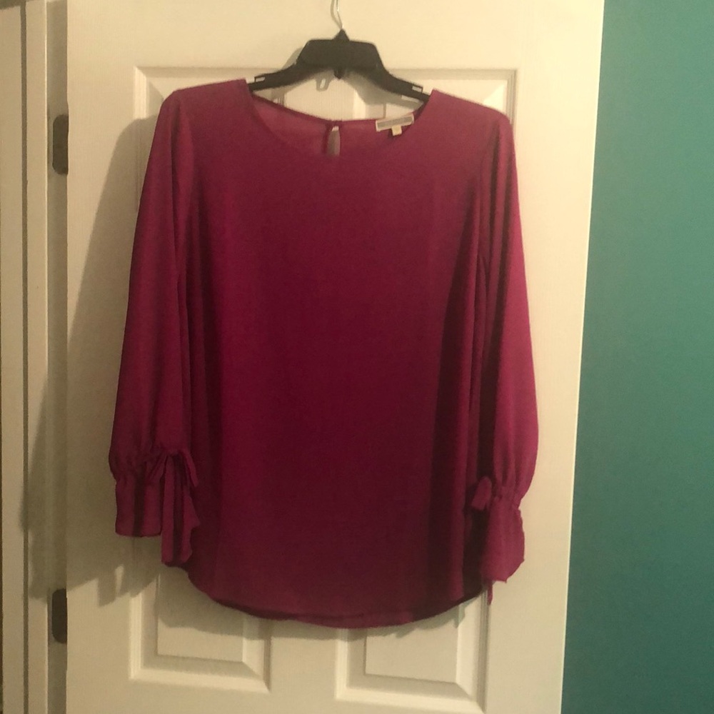 Purple flowy blouse with bows on the wrist.